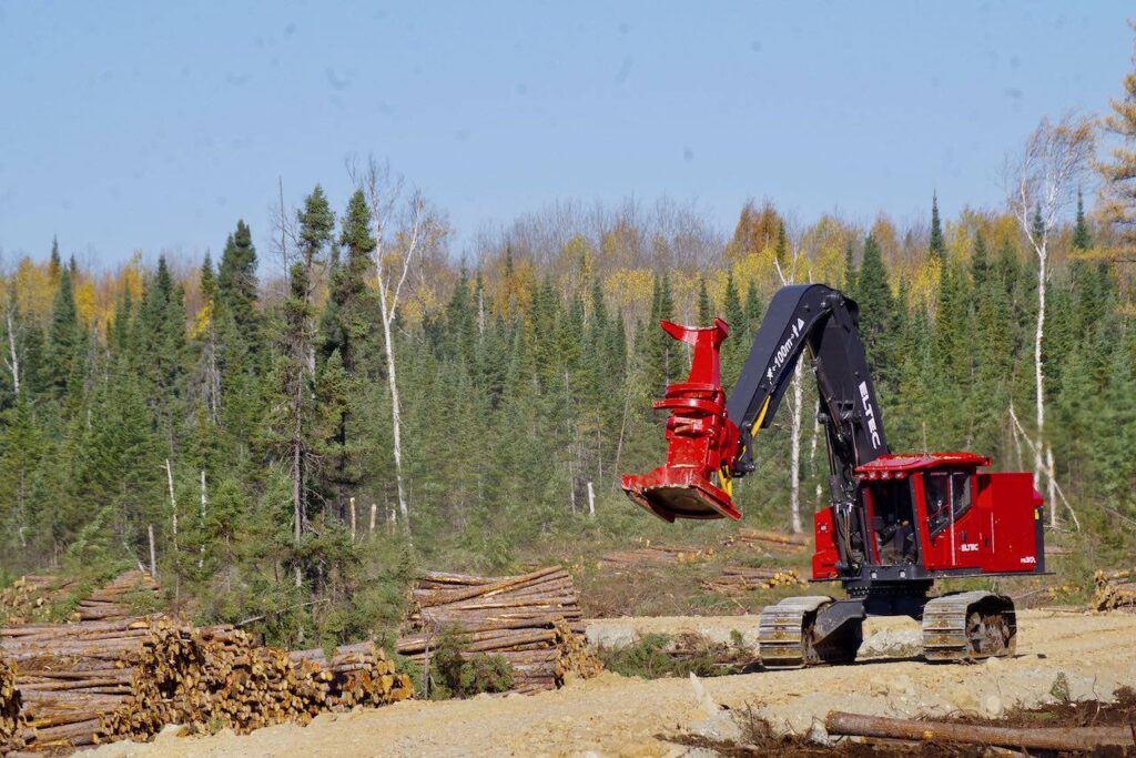 Eltec feller buncher with a Quadco head moving around a job site in a forest.