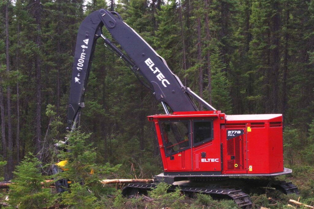 ELTEC feller harvester scooping up logs in a forest